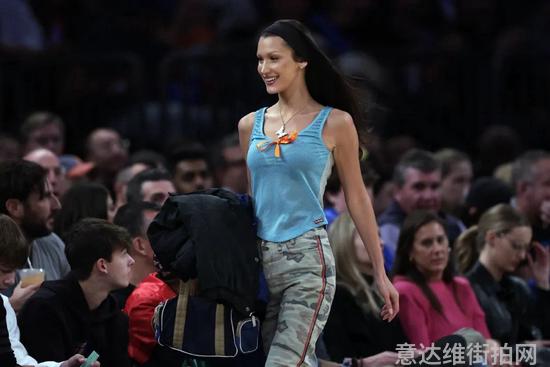 Bella去看NBA常规赛，笑着走向自己的座位